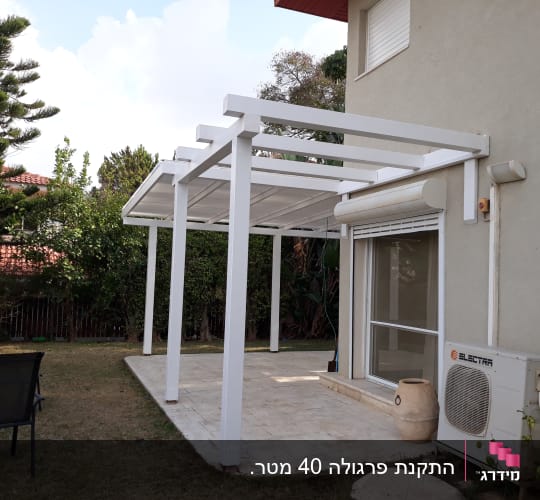פרגולה לבנה מעץ בחצר הבית ליד חלון גדול